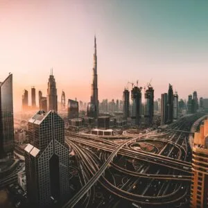 Aerial view of the Dubai skyline at dusk, with the Burj Khalifa rising above the Sheikh Zayed Road interchange