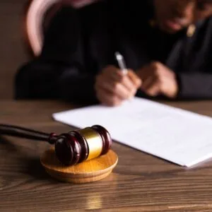 Judge signing a court ruling beside a gavel, representing UAE penalties for buying or selling a visa