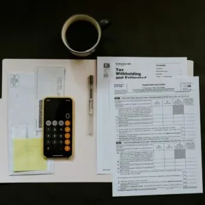 Calculator and paperwork on a desk, reviewing a UAE visa service fee for an overcharge